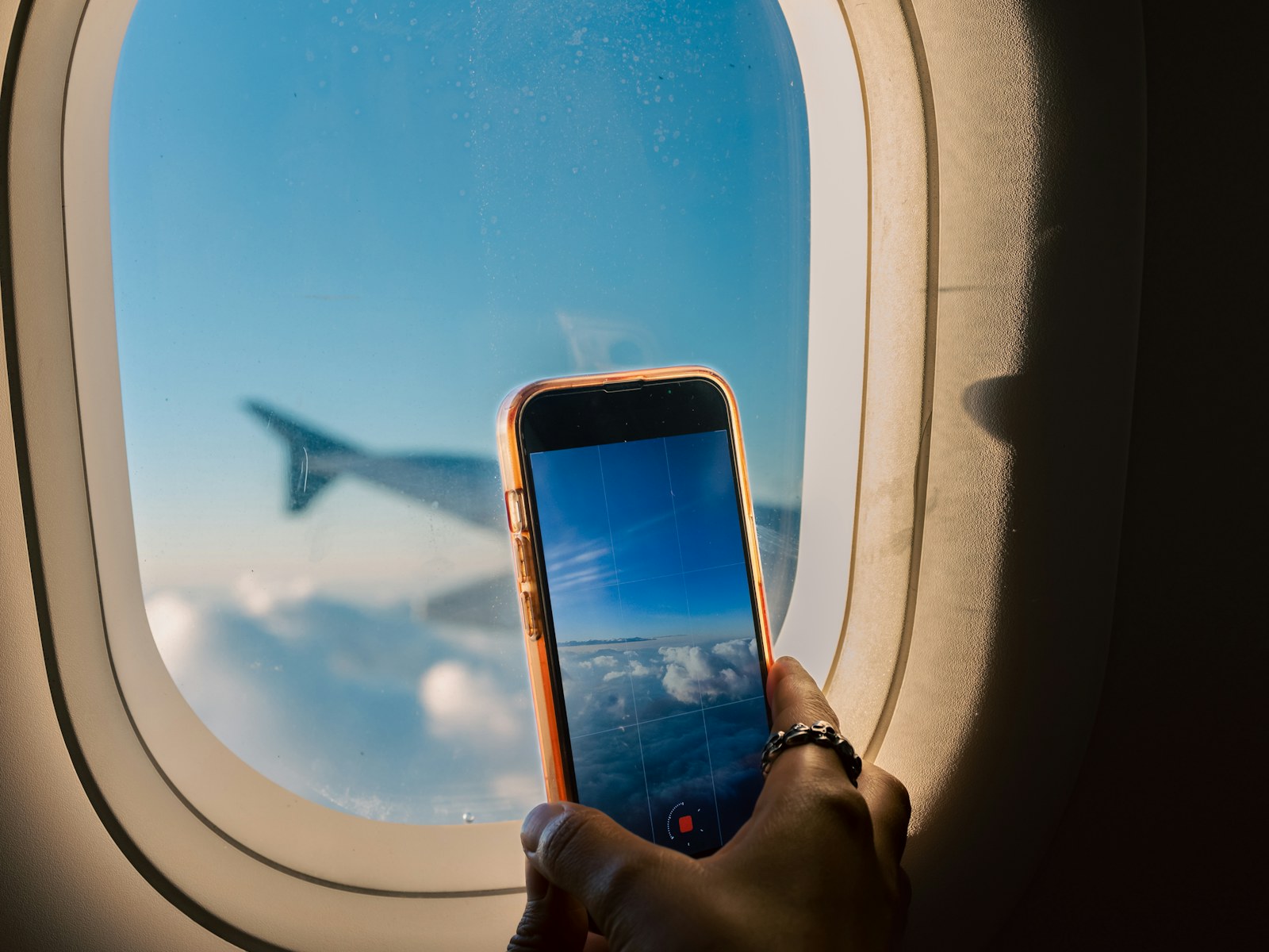Stylised illustration of a traveller with a smartphone at an airport window